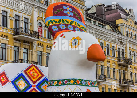 Statue de poulet peint ukrainien en face d'un bâtiment jaune à Kiev Banque D'Images