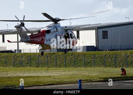 HM hélicoptère des garde-côtes, Portland, Dorset. En prenant part à un exercice de sauvetage du patient. Banque D'Images