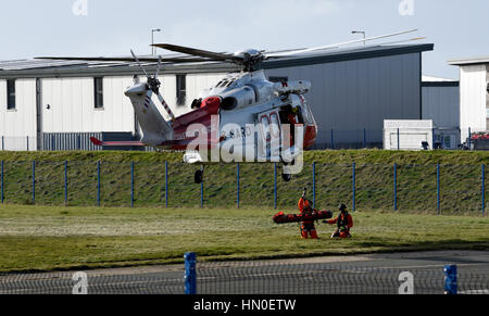 HM hélicoptère des garde-côtes, Portland, Dorset. En prenant part à un exercice de sauvetage du patient. Banque D'Images