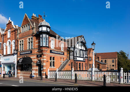 Une vieille dame avec un bâton de marche, une marche dernières PizzaExpress à côté d'un pont sur la rivière Medway, Tonbridge, Kent, UK Banque D'Images