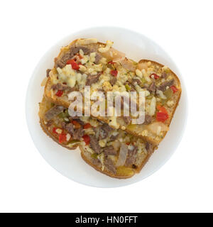 Vue de dessus de deux pièces d'un steak avec du fromage et des légumes sur une plaque sandwich isolé sur un fond blanc. Banque D'Images