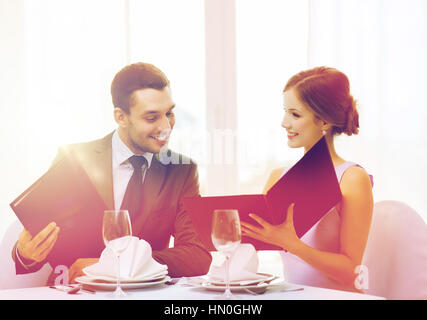 Smiling couple avec des menus au restaurant Banque D'Images