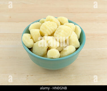 Gnocchi de pommes de terre simple dans un bol vert en haut d'une table en bois. Banque D'Images