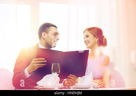 Smiling couple avec menu au restaurant Banque D'Images