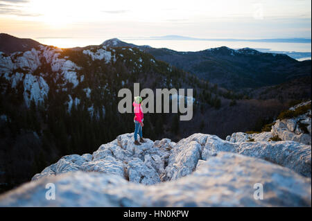 Une femme debout sur le haut de la falaise, le massif du Velebit, Croatie Banque D'Images