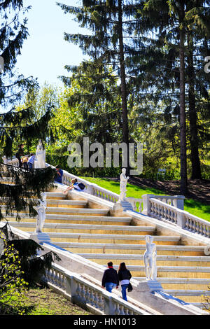 Couple en train de marcher sur le côté de la fontaine en cascade dans les jardins de Peterhof, Saint-Pétersbourg, Russie Banque D'Images