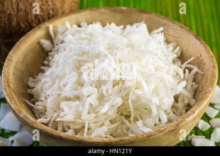Flocons de noix de coco déshydratée dans bol en bois. Banque D'Images