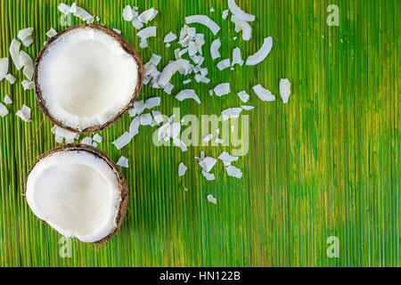 Noix de coco fraîche ouvert sur un fond vert. Banque D'Images