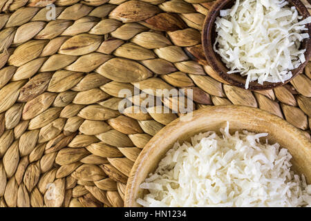 Flocons de noix de coco déshydratée dans bol en bois. Banque D'Images