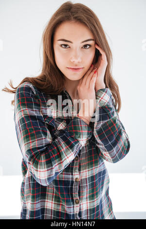 Photo de belle femme debout sur fond blanc alors que la caméra regarde Banque D'Images