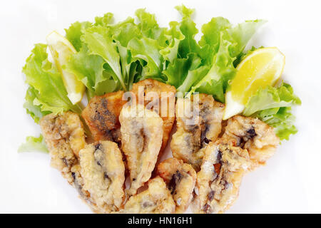 Plat typique de la cuisine napolitaine en Italie. Panés les anchois dans la farine, puis l'oeuf, frits dans l'huile d'arachide. Prêt repas accompagné d'une salade verte. Banque D'Images