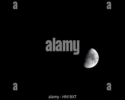 La lune vu de l'Angleterre sur un soir de février. La lune est au premier trimestre croissant Banque D'Images