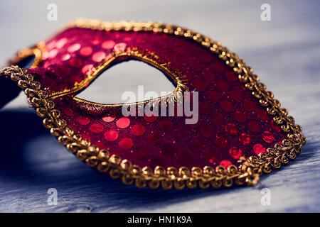 Libre d'un élégant masque carnaval rouge et or sur une surface en bois rustique Banque D'Images