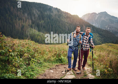 Smiling friends trekking ensemble dans les collines Banque D'Images