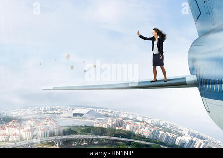 Businesswoman standing on aile d'avion et de prendre selfies Banque D'Images