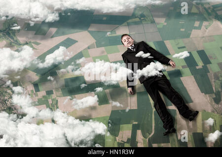 Kid garçon élégant costume d'affaires dans le cloud sur sky en haut Banque D'Images