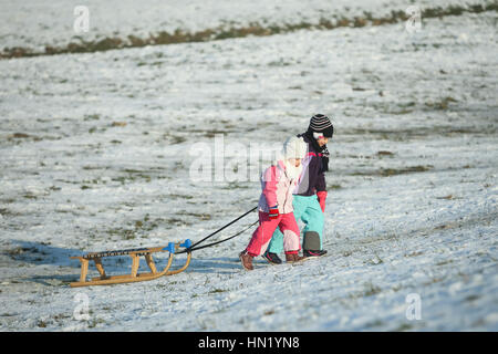 ZAGREB, CROATIE - 15 janvier 2017 : deux enfants en tirant le traîneau jusqu'à la colline à l'heure d'hiver à Zagreb, Croatie. Banque D'Images