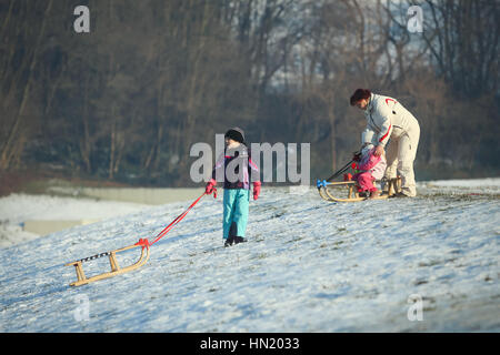 ZAGREB, CROATIE - 15 janvier 2017 : Jeunes lugeurs en bas de la colline en présence d'une femme adulte à l'heure d'hiver à Zagreb, Croatie. Banque D'Images