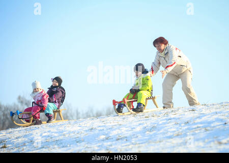 ZAGREB, CROATIE - 15 janvier 2017 : Jeunes lugeurs en bas de la colline en présence d'une femme adulte à l'heure d'hiver à Zagreb, Croatie. Banque D'Images