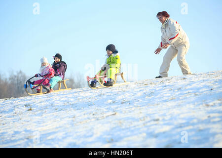 ZAGREB, CROATIE - 15 janvier 2017 : Jeunes lugeurs en bas de la colline en présence d'une femme adulte à l'heure d'hiver à Zagreb, Croatie. Banque D'Images