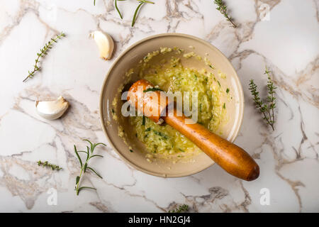 La sauce à l'ail avec le citron, le thym et le romarin dans un bol sur la table Banque D'Images