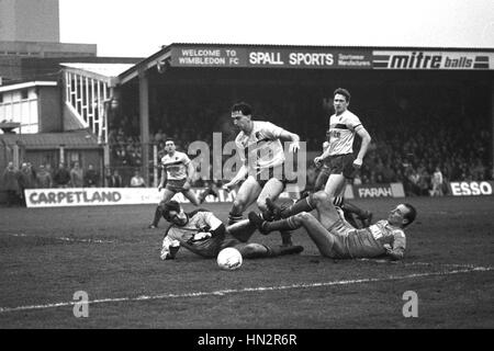 Le Wimbledon Alan Cork (à droite) se termine sur le sol après son tir au but, sauvé par le gardien du Watford Tony Coton, aujourd'hui, au cours de la Barclays League Division One match à Plough Lane, Wimbledon. D'autres joueurs de Watford dans la boîte sont John McClelland (debout à droite) et Mark Morris (centre). Banque D'Images