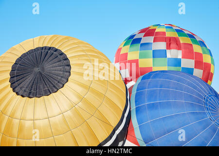 Colorful ballons à air chaud du gonflage au sol, ciel bleu Banque D'Images