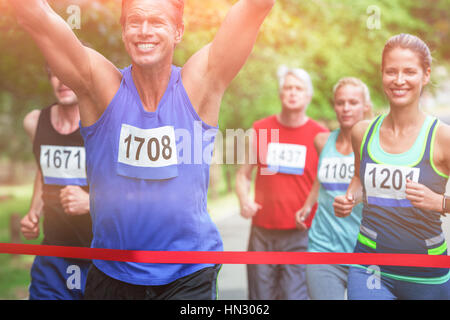 Athlète masculin de marathon de franchir la ligne d'arrivée dans la région de park Banque D'Images