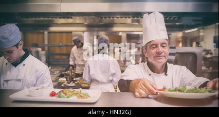 Chef salade contrôle dans la cuisine avant service Banque D'Images