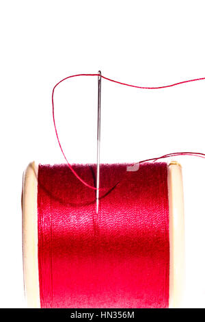 Coton Rouge bobine (bobine) et l'aiguille à coudre et du fil isolé sur fond blanc Banque D'Images
