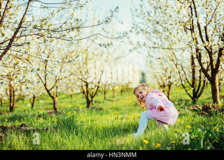 L'exécution de l'enfant en plein air arbres fleuris. Traitement de l'art et de retouche Banque D'Images