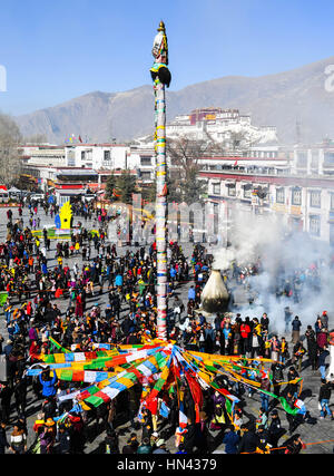 (170208) -- Lhassa, le 8 février 2017 (Xinhua) -- Les dévots accrocher les drapeaux de prières à un poteau près du temple du Jokhang à Lhassa, capitale du sud-ouest de la Chine, région autonome du Tibet, le 8 février 2017. Comme le Nouvel An tibétain s'approche, les drapeaux de prières attachées sur les cinq pôles entourant le Temple de Jokhang ont été remplacés par de nouveaux conformément à la tradition tibétaine. (Xinhua/Purbu Zhaxi) (lb) Banque D'Images