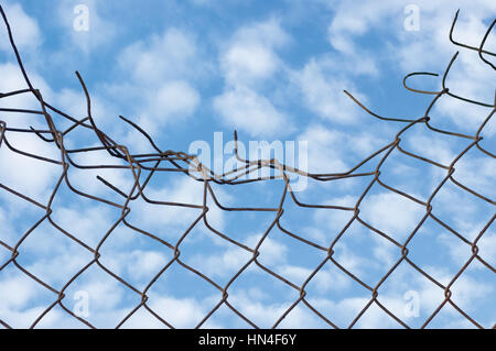 Grynge de rusty écrasée sur le fil de la clôture de sécurité, plus de nuages, le ciel, les nuages et le ciel Banque D'Images