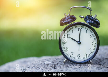 Réveil dans la verte nature background, bell rétro de l'horloge à 10 heures. Banque D'Images