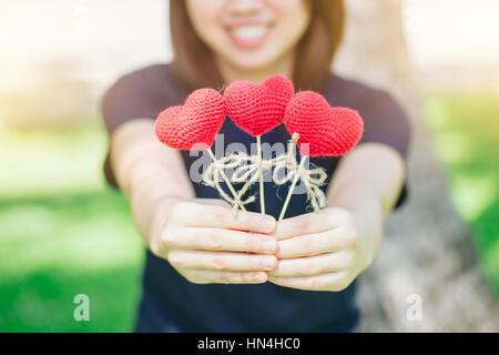 Nouvel ami aime rencontrer et sourire mignon date Thai asiatique teen main courante red heart sweet loving symbole de prendre soin ou de charité pour aider à vous. Banque D'Images