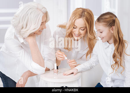 Mère Pleasat clous de peinture de sa fille Banque D'Images