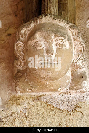 Une tête de pierre sculptée dans le support de l'Afrique du porche de l'église paroissiale de North Elmham, Norfolk, Angleterre, Royaume-Uni. Banque D'Images