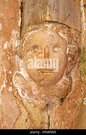 Une tête de pierre sculptée dans le support de l'Afrique du porche de l'église paroissiale de North Elmham, Norfolk, Angleterre, Royaume-Uni. Banque D'Images