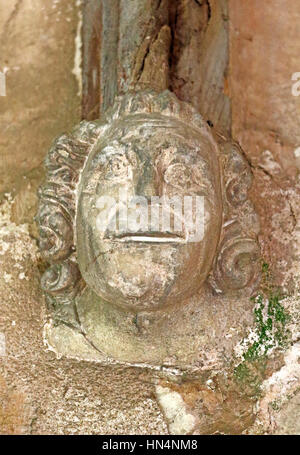 Une tête de pierre sculptée dans le support de l'Afrique du porche de l'église paroissiale de North Elmham, Norfolk, Angleterre, Royaume-Uni. Banque D'Images