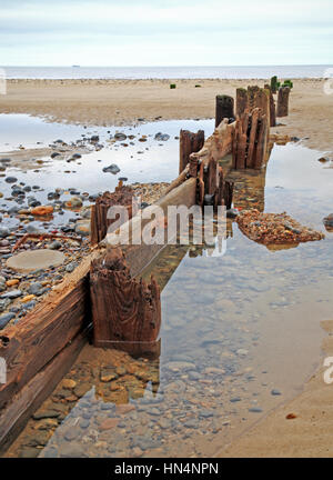 Un vieux brise-lames en bois érodé sur la plage de Mundesley, Norfolk, Angleterre, Royaume-Uni. Banque D'Images