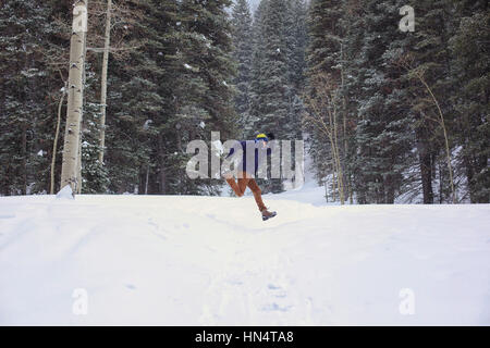 Un seul homme passe dans le bois du Grand Canyon Cottonwood, de l'Utah près de Salt Lake City. C'est l'hiver et il y a de la neige au premier plan. Banque D'Images