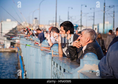 ISTANBUL, TURQUIE - 6 novembre : une rangée d'hommes fumant et de la pêche sur le pont de Galata à Istanbul, Turquie, le 6 novembre 2009. Le pont historique sp Banque D'Images