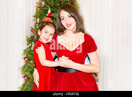 Portrait d'fazakh enfant asiatique, fille et maman autour d'un arbre de Noël décoré. Kid en vacances nouvelle année Banque D'Images