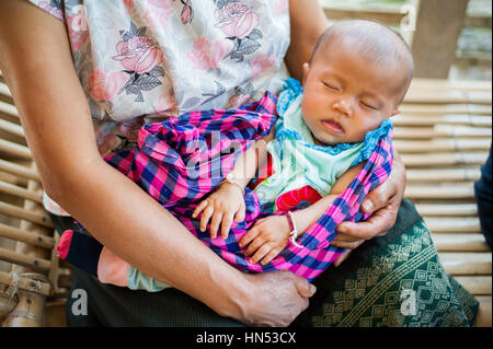 Femme tenant un bébé de Huay Bo, village du nord du Laos. Banque D'Images