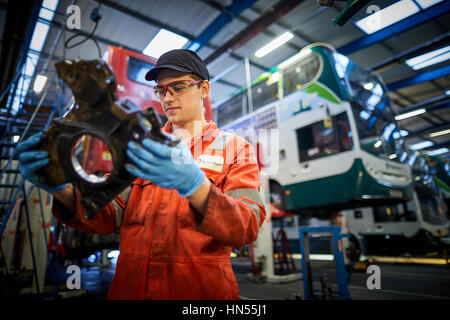 Un jeune apprenti mécanicien monteur d'adolescent ventilé fixation moteur au bus à impériale bus Stagecoach opérateurs Wythenshawe depot à Manchester, Banque D'Images