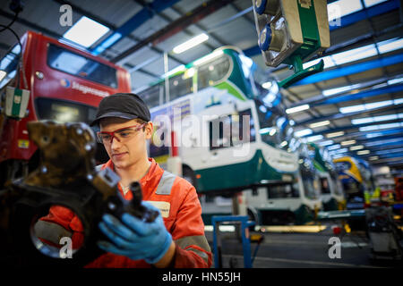 Un jeune apprenti mécanicien monteur d'adolescent ventilé fixation moteur au bus à impériale bus Stagecoach opérateurs Wythenshawe depot à Manchester, Banque D'Images