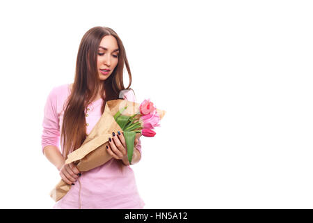 Belle fille de la robe rose avec des fleurs tulipes en mains sur un fond blanc. Isolé sur blanc. Banque D'Images