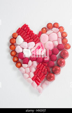 Chocolats Assortis placé en forme de coeur sur fond blanc Banque D'Images