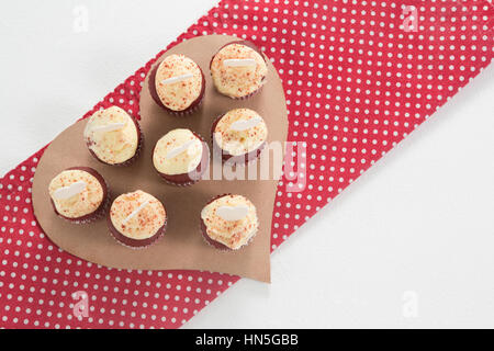 Cup cakes en forme de coeur sur papier contre fond blanc Banque D'Images