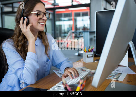 Graphiste femme travaillant sur ordinateur at desk in office Banque D'Images